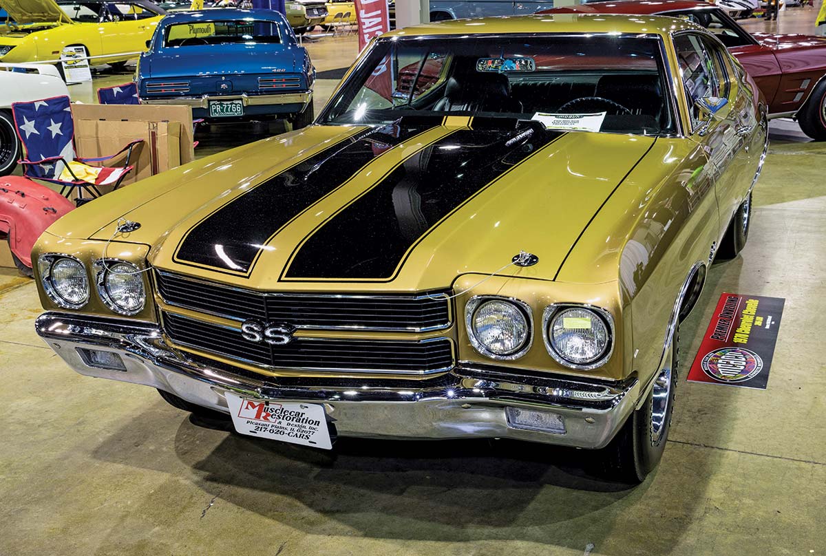 Close-up photograph perspective of a dark gold/black '70 L89 Chevelle custom-themed car in a display area of a showroom floor, which this car is owned by Phil Mitchell and was restored by MuscleCar Restoration & Design in Pleasant Plains, Illinois