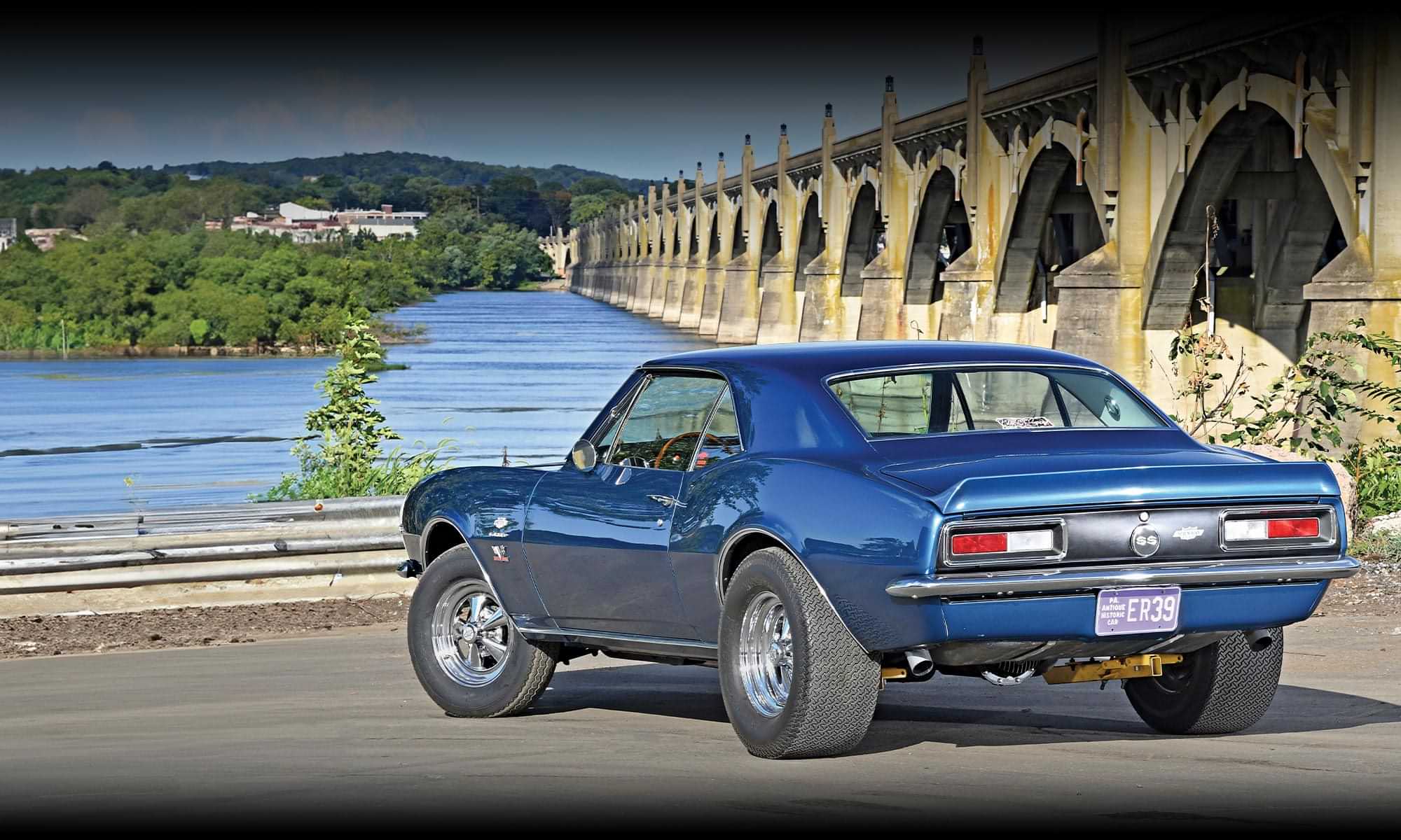 rear quarter view of the '67 Camaro SS parked near a large causeway