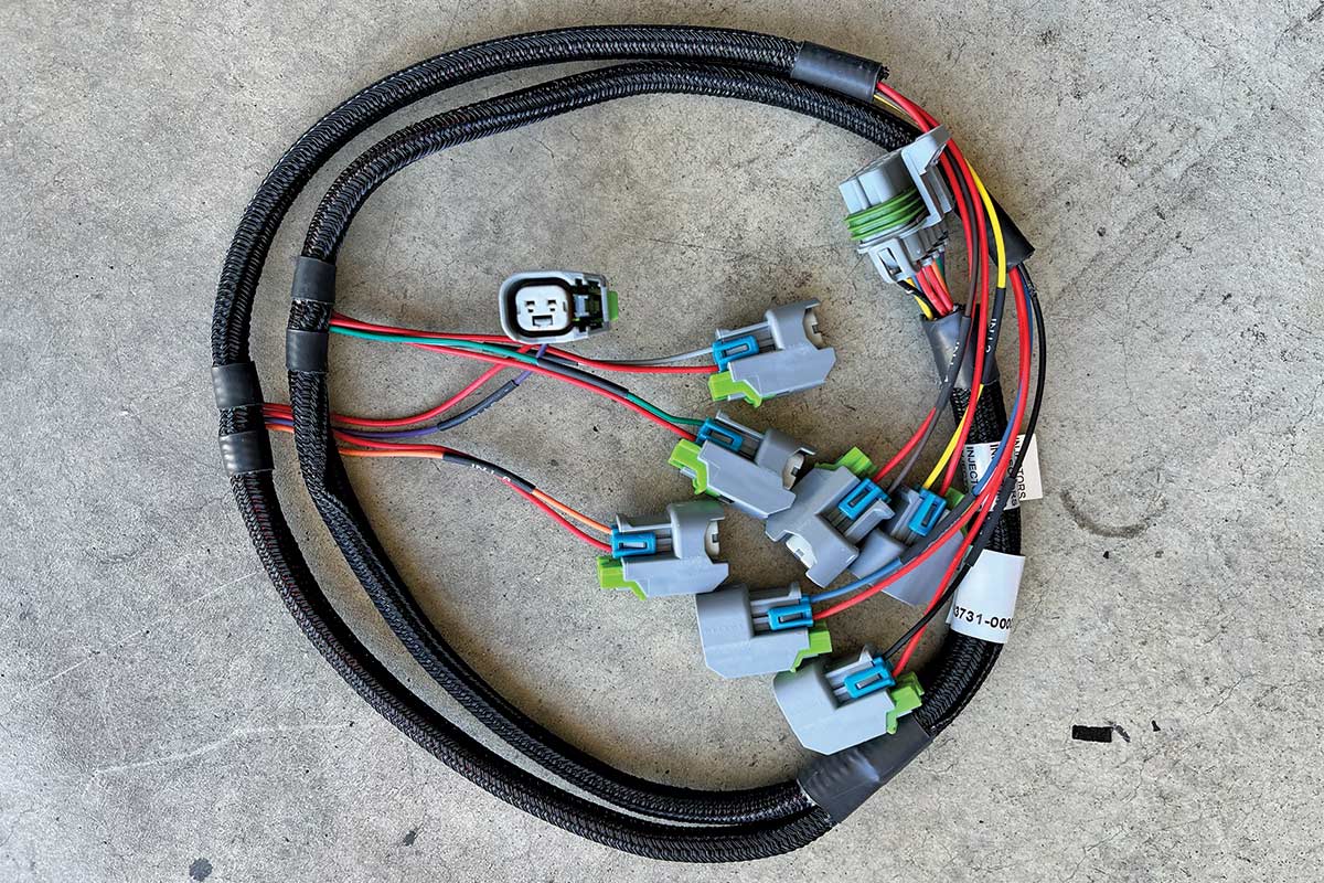 Wires in a black sheath, wrapped up and laying on the ground