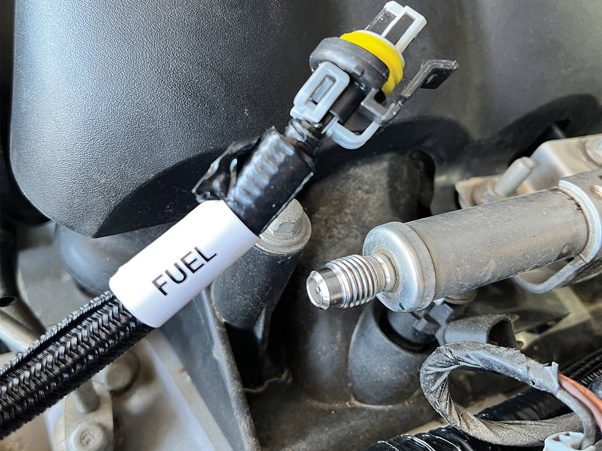 Close up of a fuel pressure sensor with a white label that says fuel