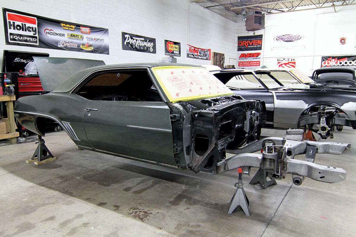 Half of a body of a Chevy in a garage on a stand