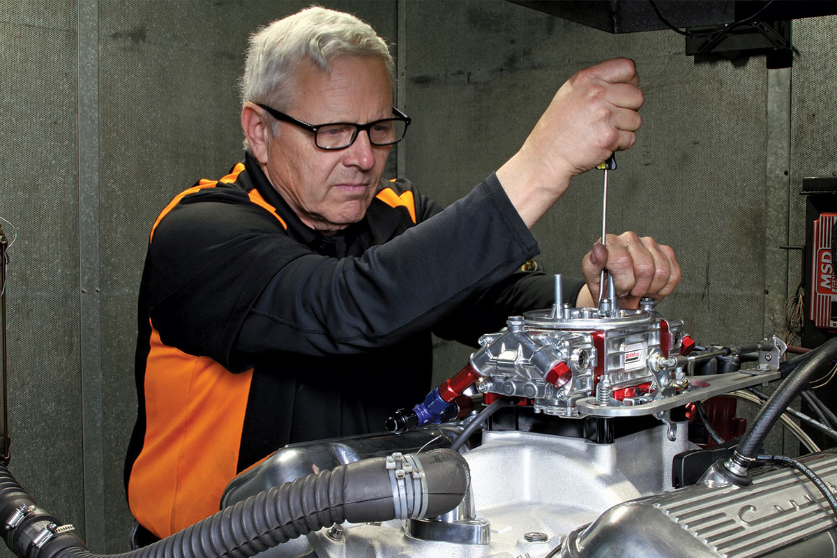 Man in glasses working on a car part on a table