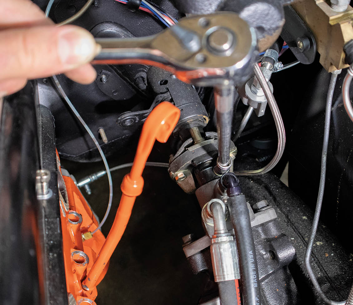 Then, outside in the engine bay, we unbolted the rag joint from the steering box. We’ll use the Flaming River U-joint instead of the rag joint to adapt the new column to our aftermarket quick-ratio power steering box from Detroit Speed.