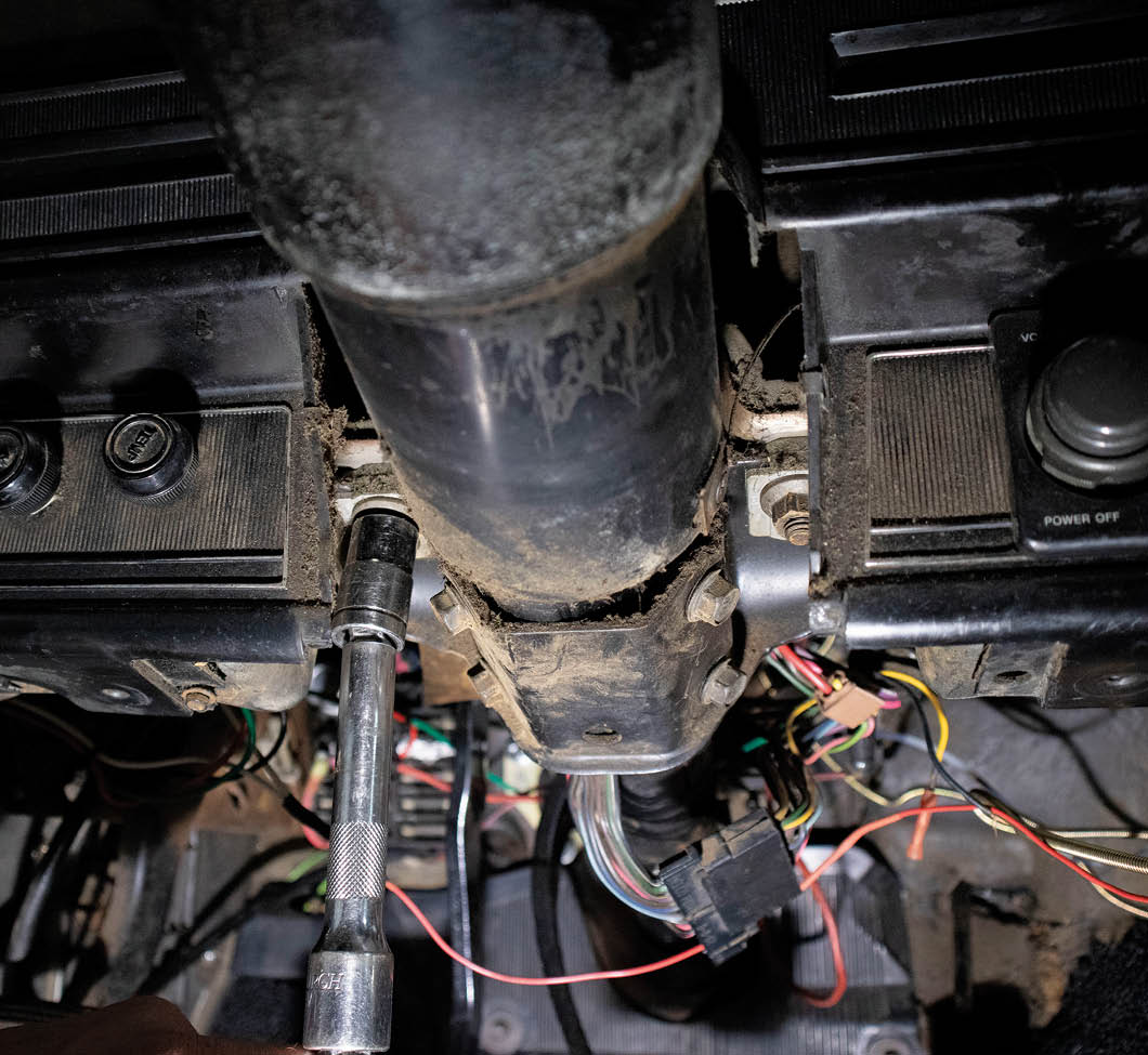 Two 9/16-inch nuts and unplugging the wiring harness are all that stand in the way of us removing the old column.