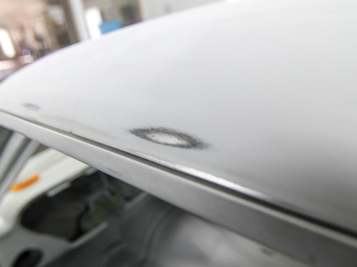 A dark blemish on a piece of metal left from a high spot being found