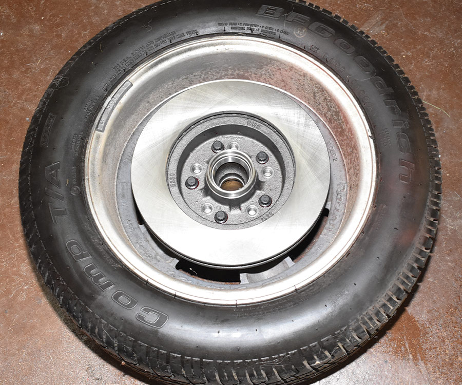 Before installation, red thread locking compound is applied to the studs, they are then torqued to 77 lb-ft. Holding the rotor while tightening the studs is made easier by placing it in a wheel and tire.