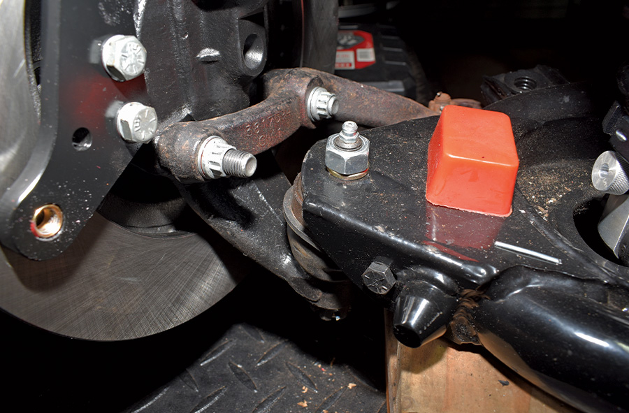 At the bottom of the caliper bracket the supplied fasteners go through the bracket, spindle, and steering arm. They’re secured with self-locking 12-point nuts.