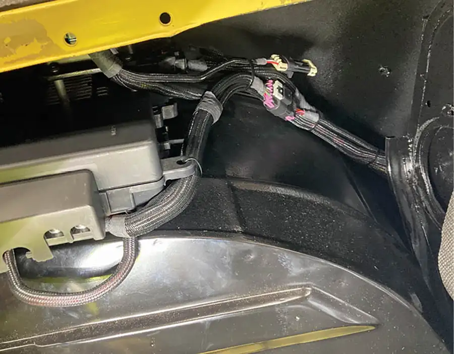 The ECU/TCU package sits inside the fender from the fuse panel and all the wiring disappears deep into the fender and under the kick panel, out of view.