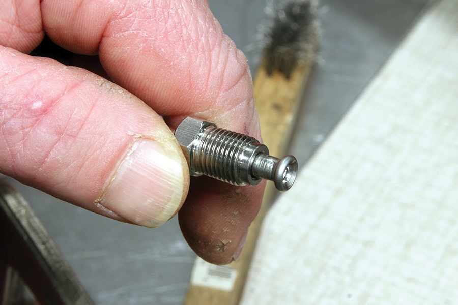 closeup of hand holding hard line with flare and fitting