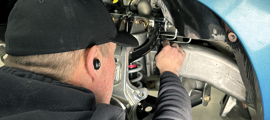 man testing the hard line near front brakes