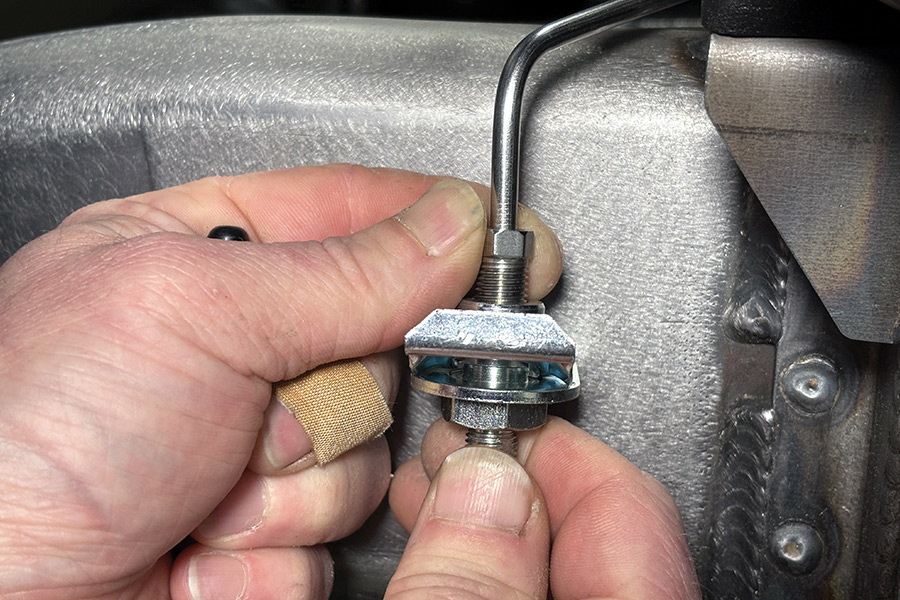 brake lines being connected to a fitting for the flexible lines, which is secured to the frame by weld-on tabs supplied by Inline Tube