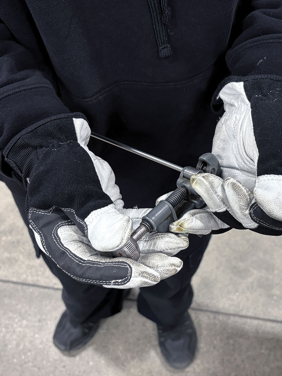 hand holding tube cutter to trim the stock