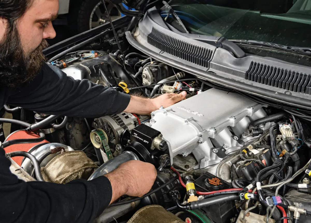 mechanic places the Holley manifold on the head surface for a preliminary size check