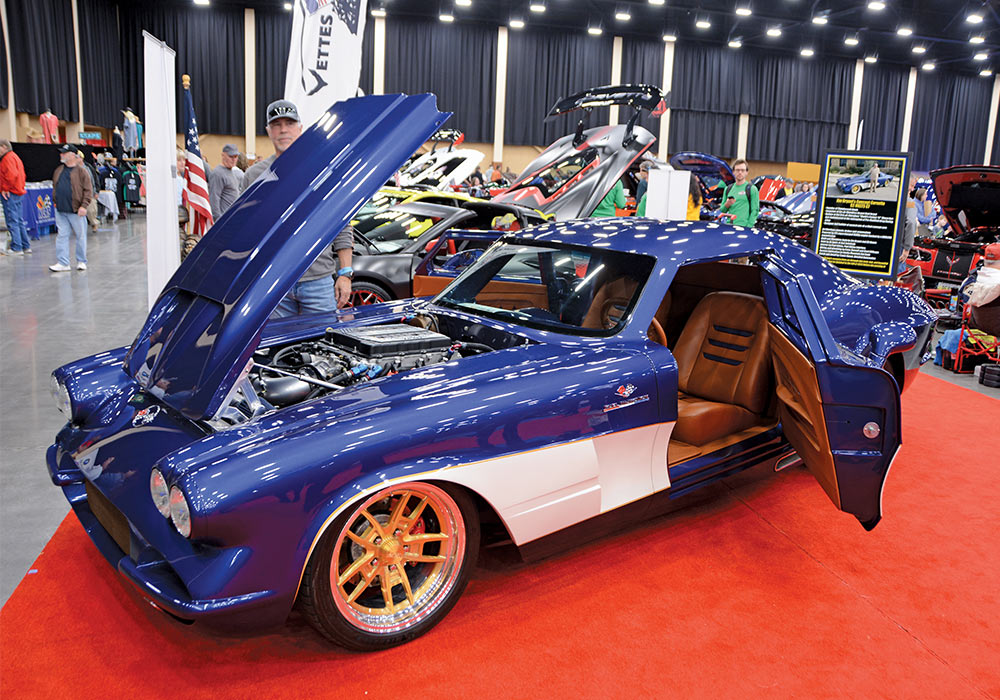 royal blue car with white detailing parked with its door and hood open 