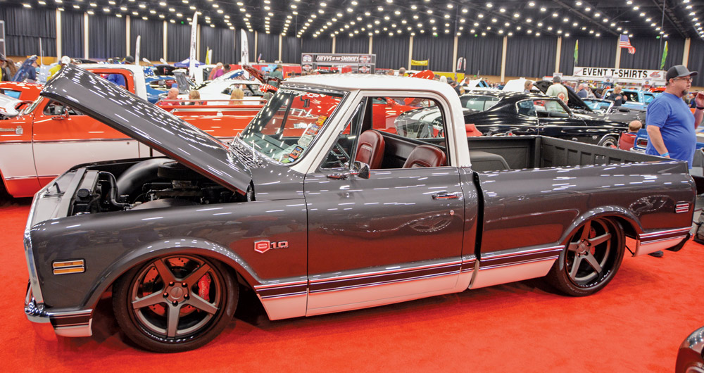 grey pickup truck with white roof and white line art displayed with its hood open 