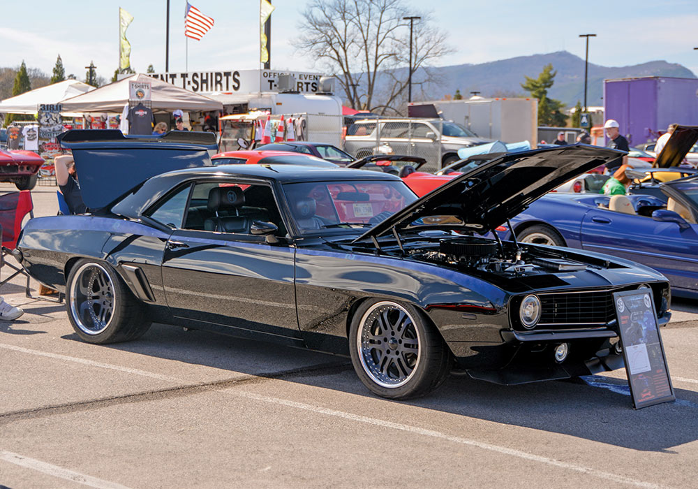 black car in an outdoor setting with its hood open 