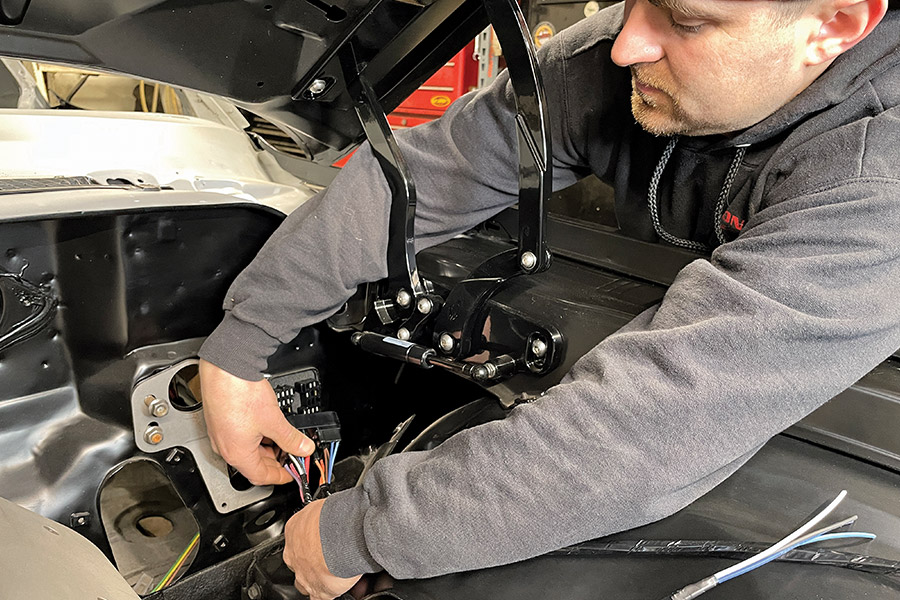 man installing car part under hood