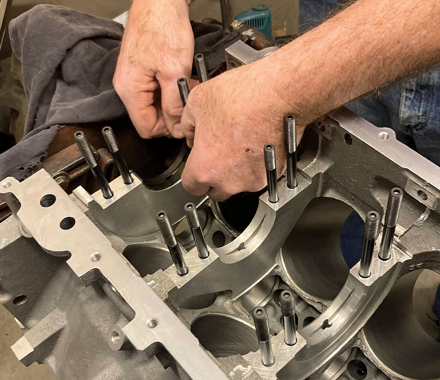 closeup of person adding side bolts on an LS engine