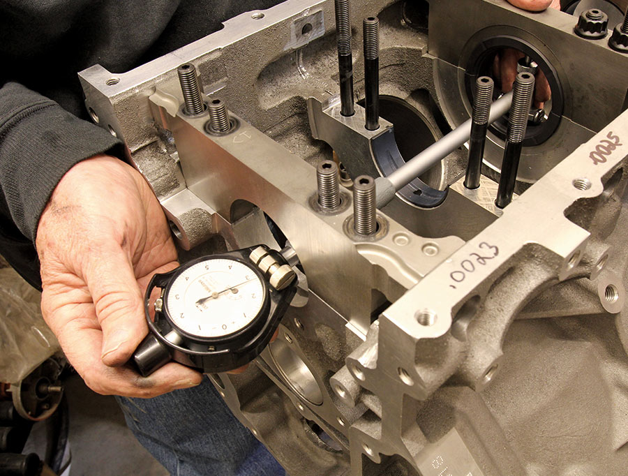 closeup of person using a dial bore gauge to measure the bearing clearances