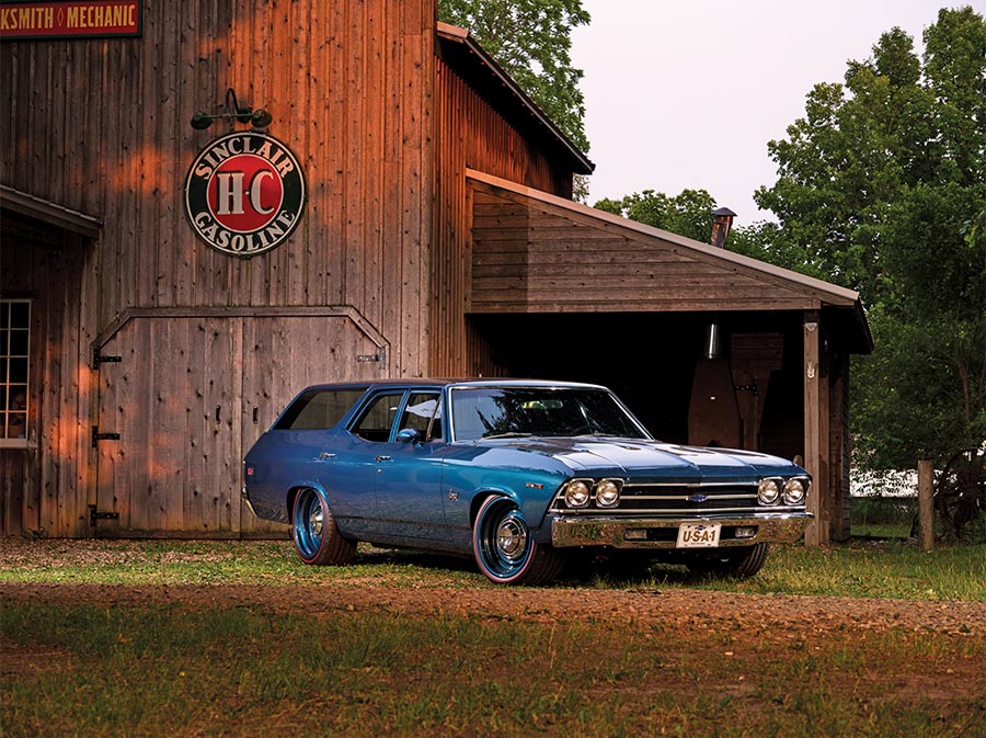 3/4 view of a blue '69 Nomad parked in front of a shed