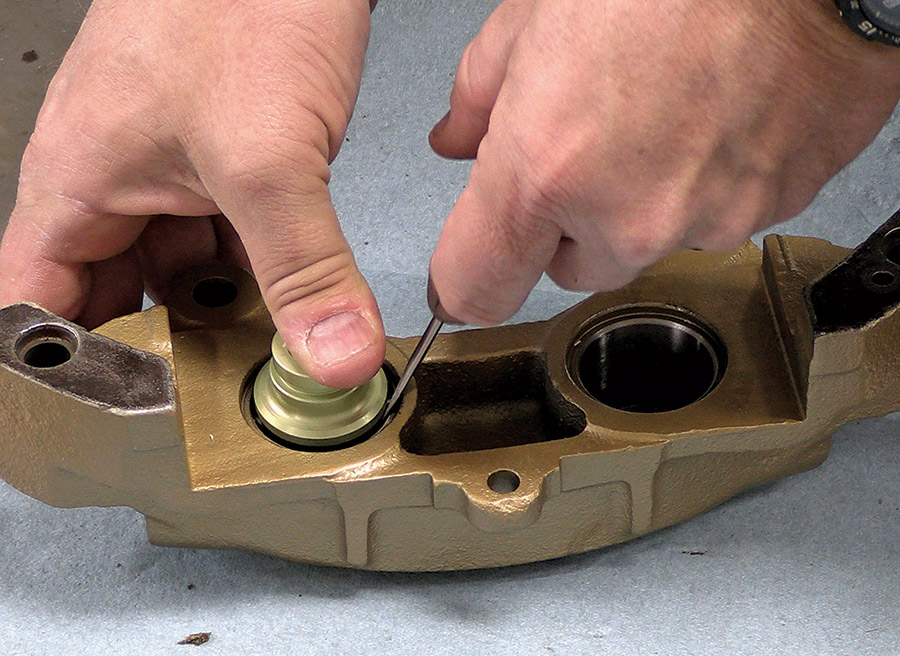 hand using thin screwdriver to install piston bore