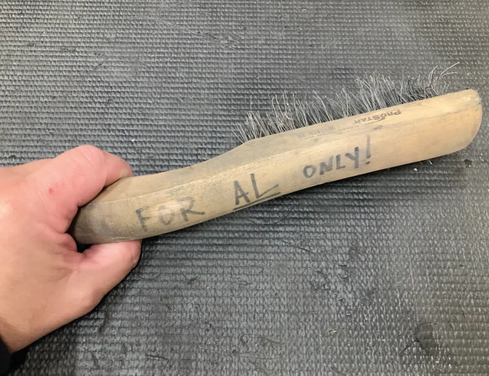 a hand holds a stainless steel brush marker labeled “For AL Only!”