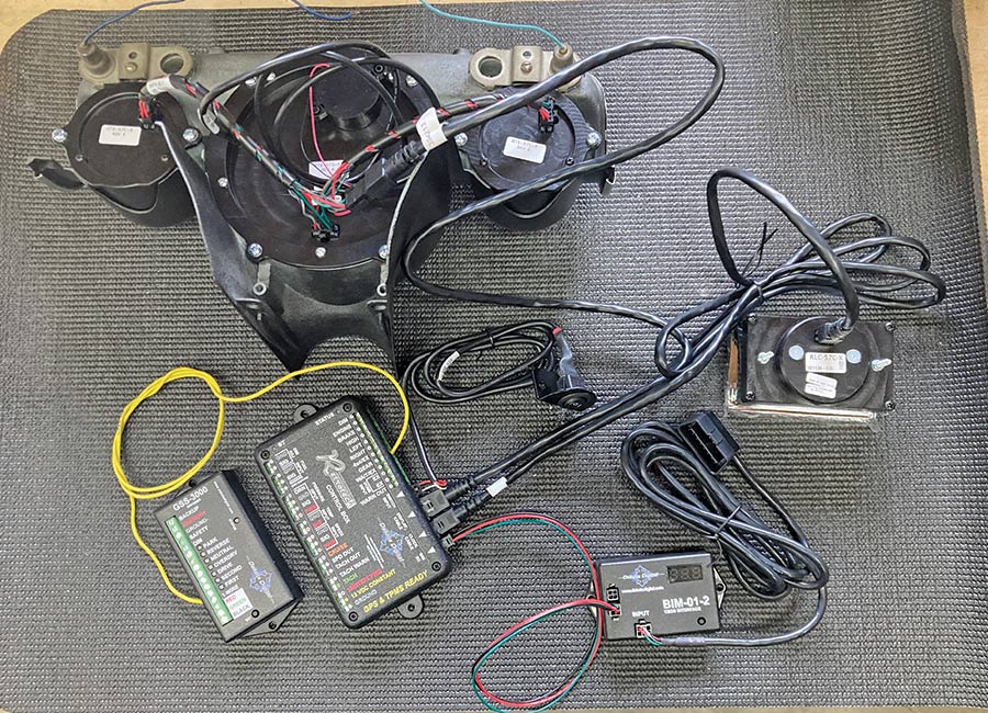 Complete setup of 1957 Chevy dashboard wiring, modules, and gauges laid out for installation