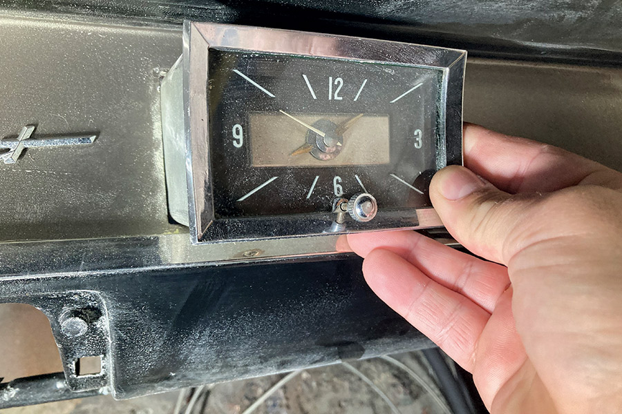 Close-up of a vintage 1957 Chevy dashboard clock during disassembly