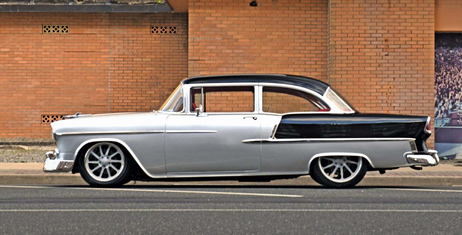 Side profile of a 1955 Chevrolet Bel Air, showing off its custom wheels and lowered suspension