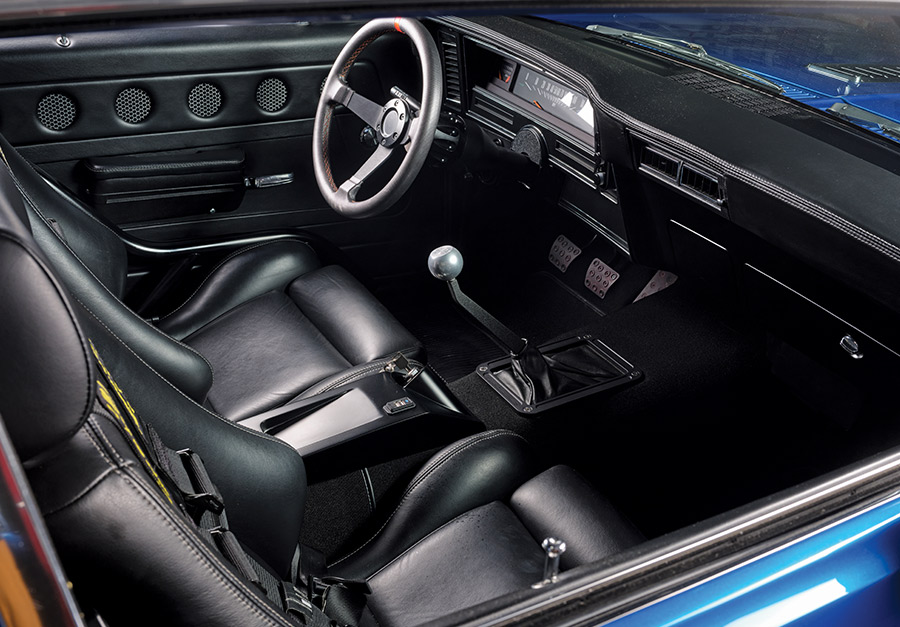 Black leather interior of the 1971 Chevrolet Nova SS with race seats, custom door panels, and a roll cage