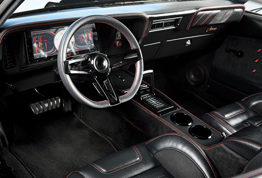 Modernized interior of the 1969 Camaro Z28, featuring custom seats with red stitching and digital gauges