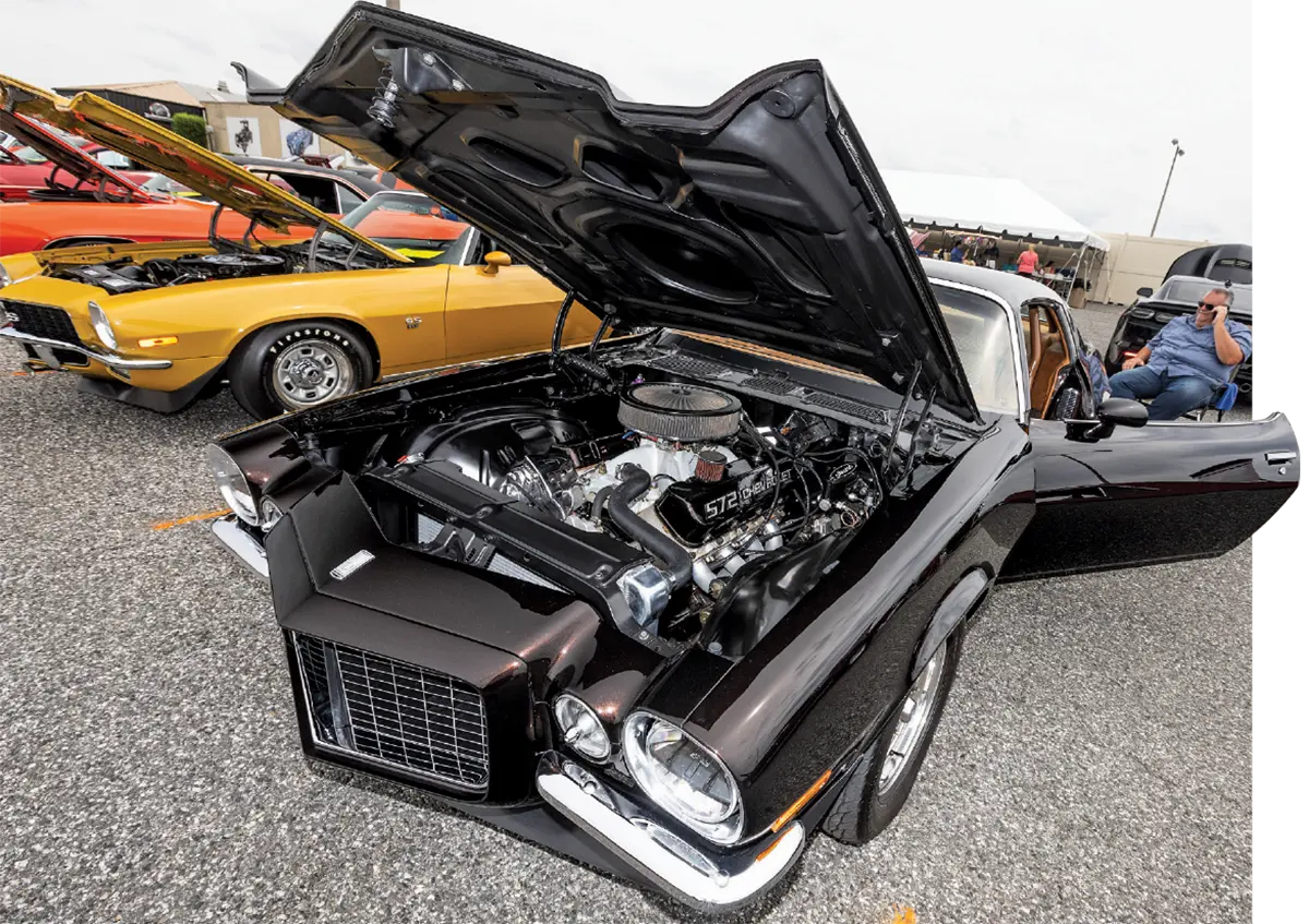 A black second-generation Camaro with a 572 big-block engine, displayed alongside a gold SS model