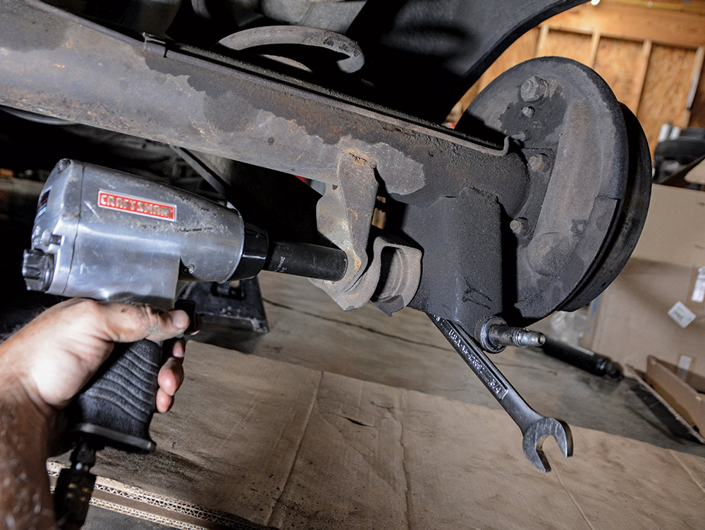 hand using impact wrench to remove bolts from lower arms