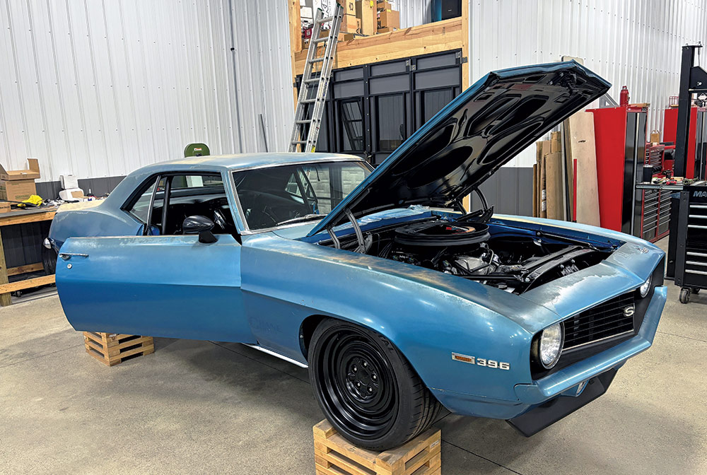 car elevated on wood crates with doors and hood open