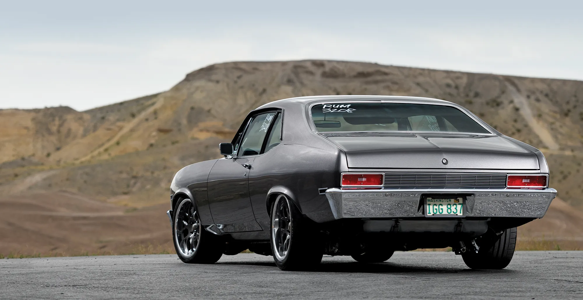 Front view of a 1971 Chevrolet Nova, featuring a custom front grille, hood stripes, and aggressive stance