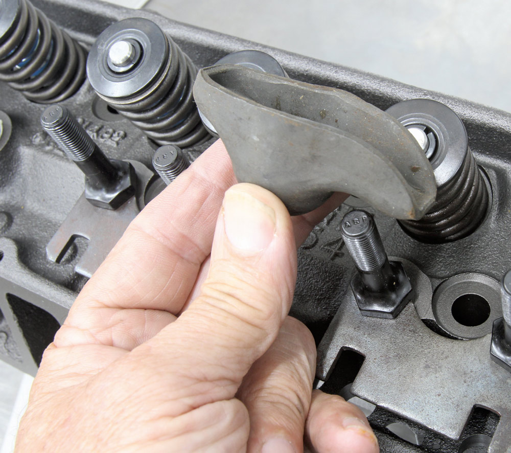 Close-up of a rocker arm being installed on a small-block Chevy cylinder head