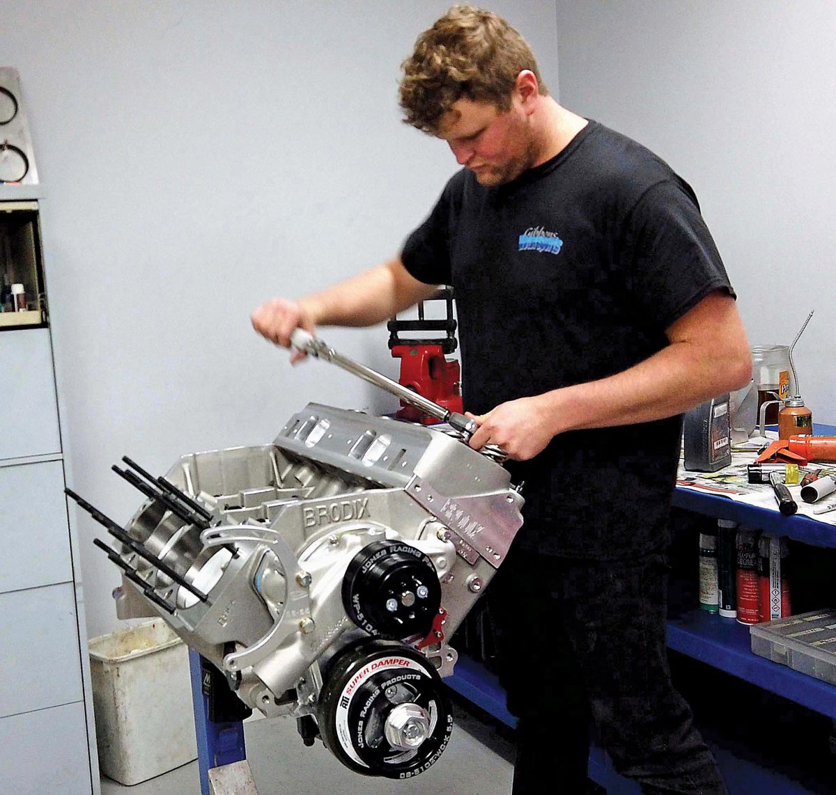 Mechanic installing components on a Chevy big block engine with a Brodix block and damper