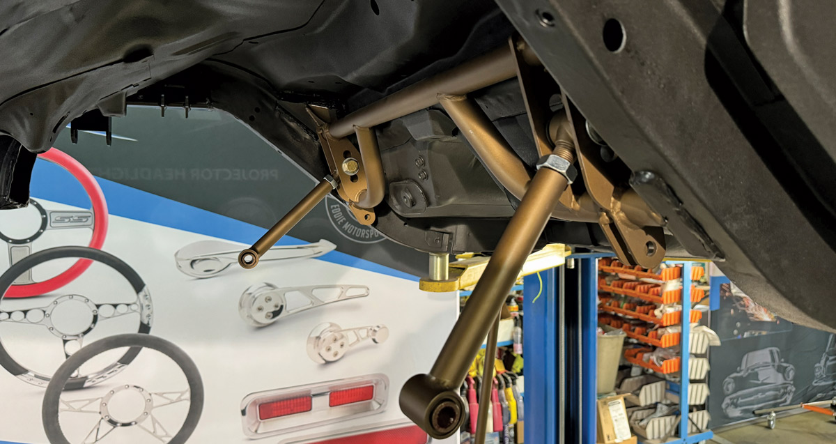 Close-up of a control arm installed with new bushings and hardware on a Chevrolet Nova