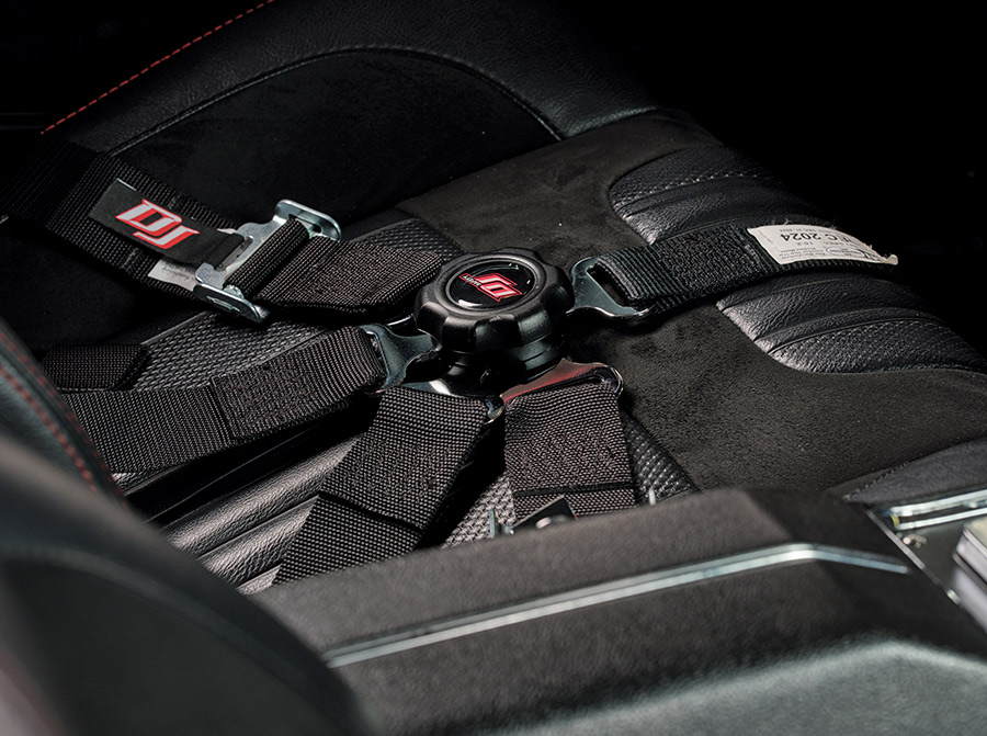 Detailed view of a DJ safety harness buckle on the racing seat in the 1970 Chevelle