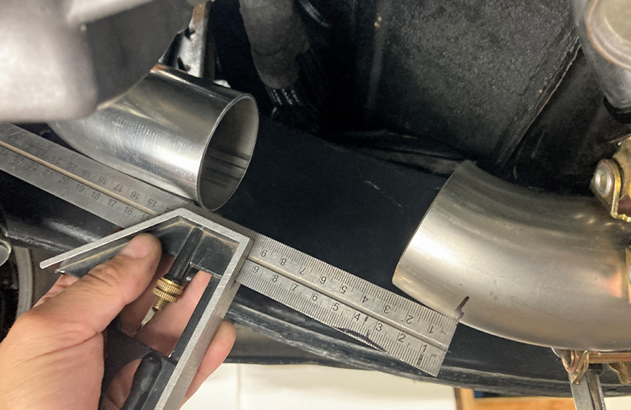 Measuring exhaust pipe alignment with a square to ensure a perfect fit during installation