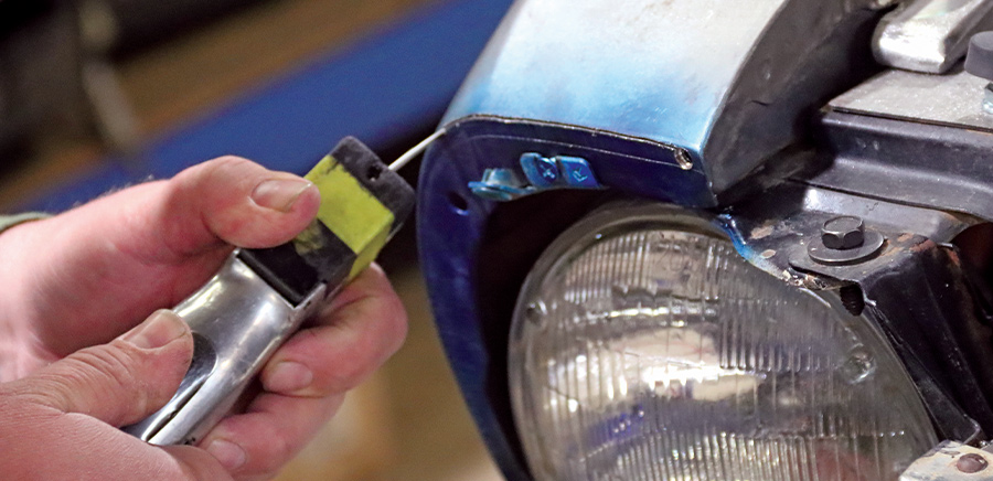 closeup of a reciprocating saw being used to create a horizontal cut across the front of each fender