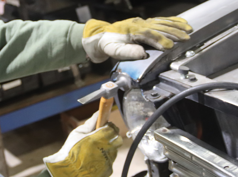 top edge of the fender being recontoured with a body hammer