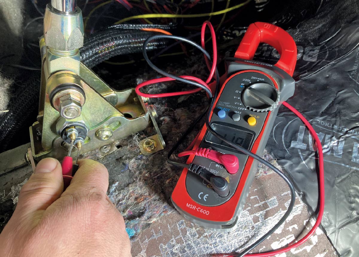 1957 Chevy Lokar shifter testing with multimeter during installation process