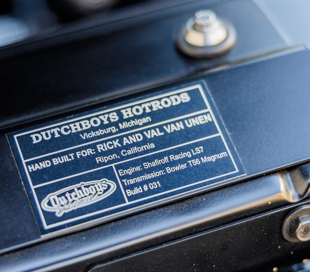 Close-up of a metal plaque on a surface, detailing vehicle specifications and custom build information.