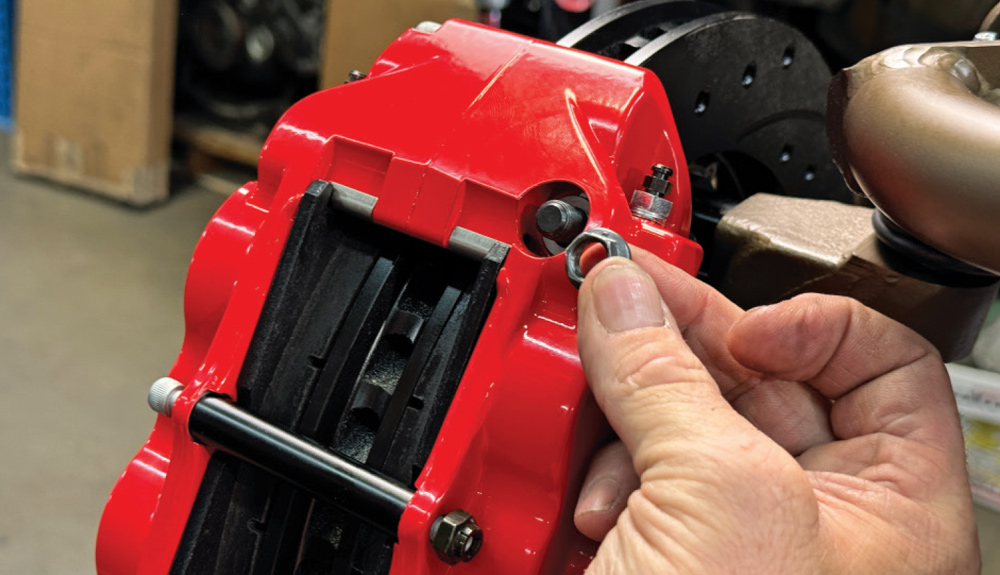 finalizing caliper installation with alignment washers on the 1972 Chevrolet Nova's brake assembly