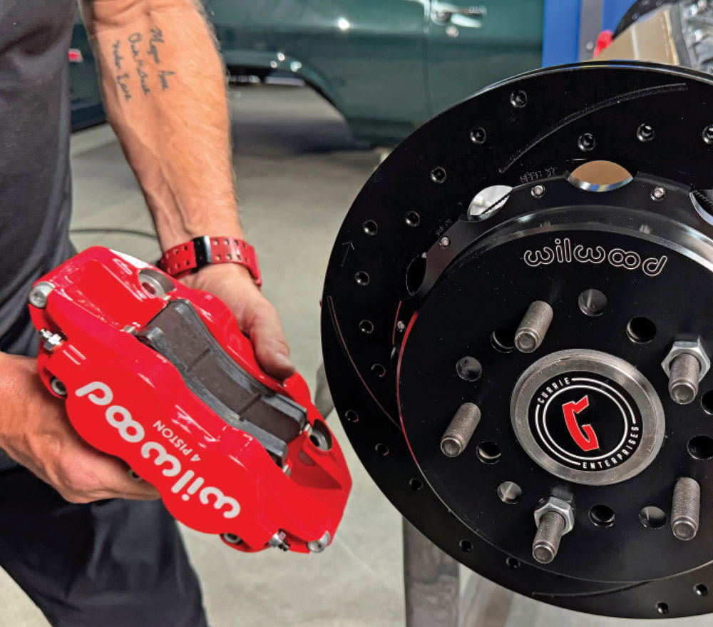 wilwood 4-piston red caliper prepared for mounting onto the rotor and hub assembly of the 1972 Chevrolet Nova