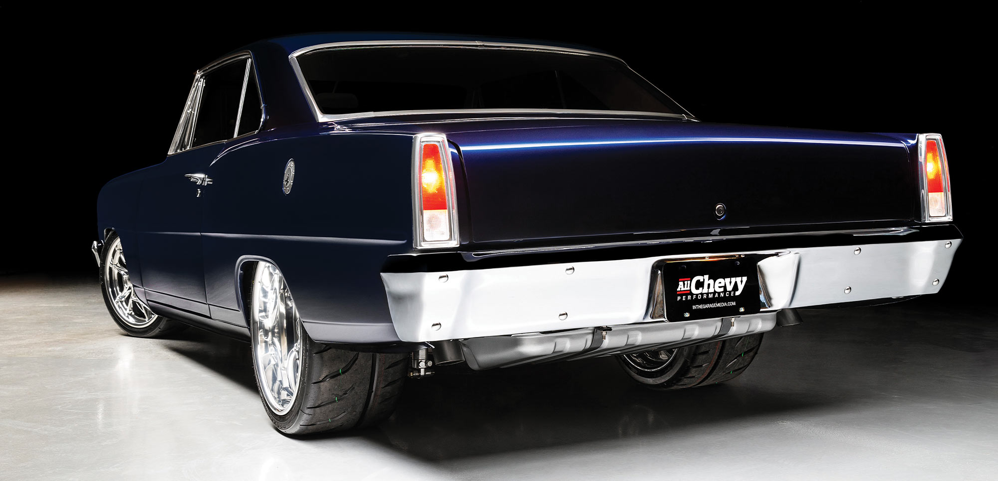 1966 Chevy Nova rear view, polished chrome bumper, classic tail lights, and wide performance tires