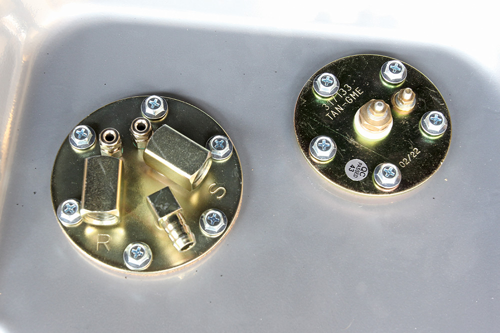 close-up of fuel tank outlet ports with return and supply labels for custom EFI setups