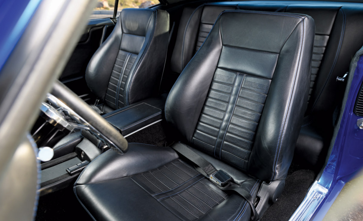 1969 Chevrolet Camaro black leather bucket seats with blue stitching, blending comfort and style