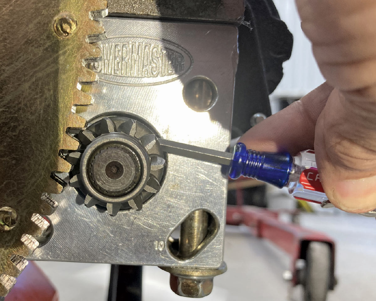 Pinion gear engagement verified with a screwdriver for proper alignment